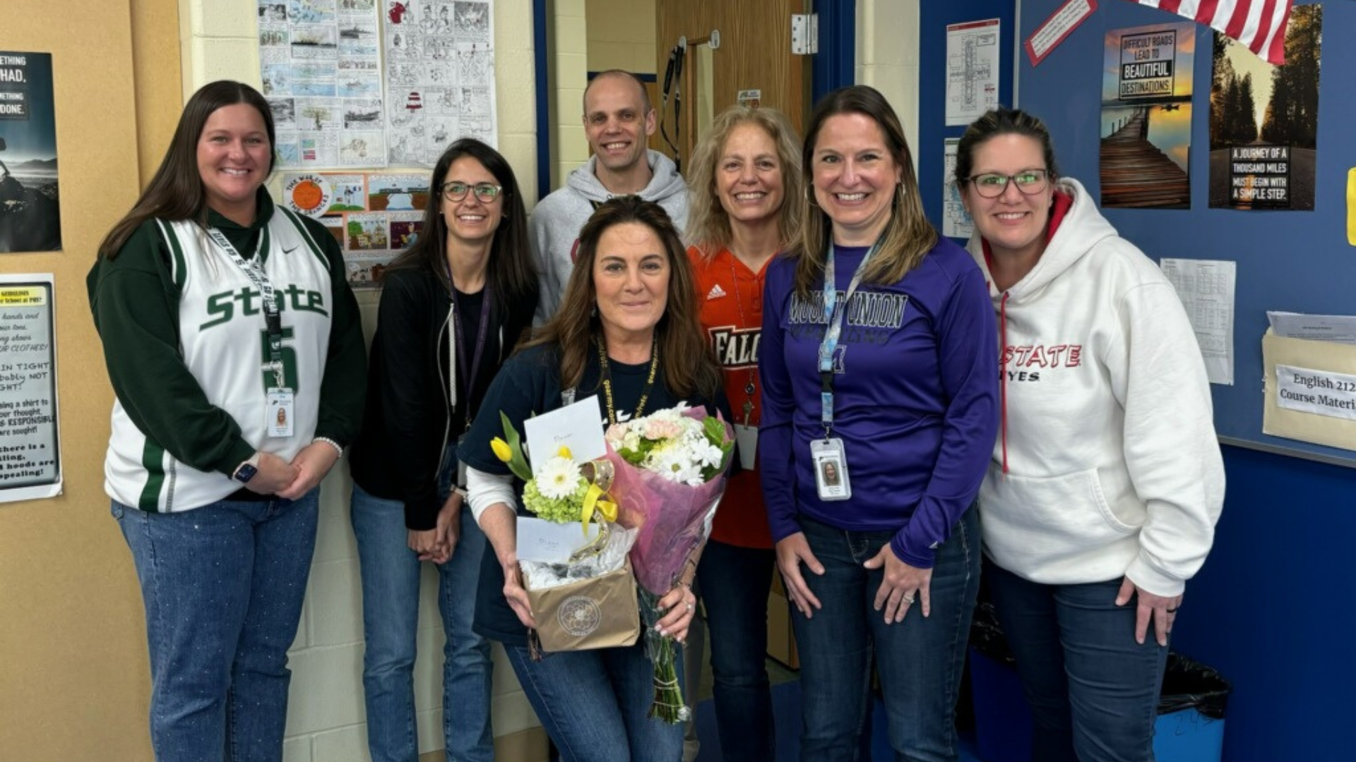 Diann Toffler (center holding flowers) poses with the PHS English Department and Assistant Principal Dake Dakolios.